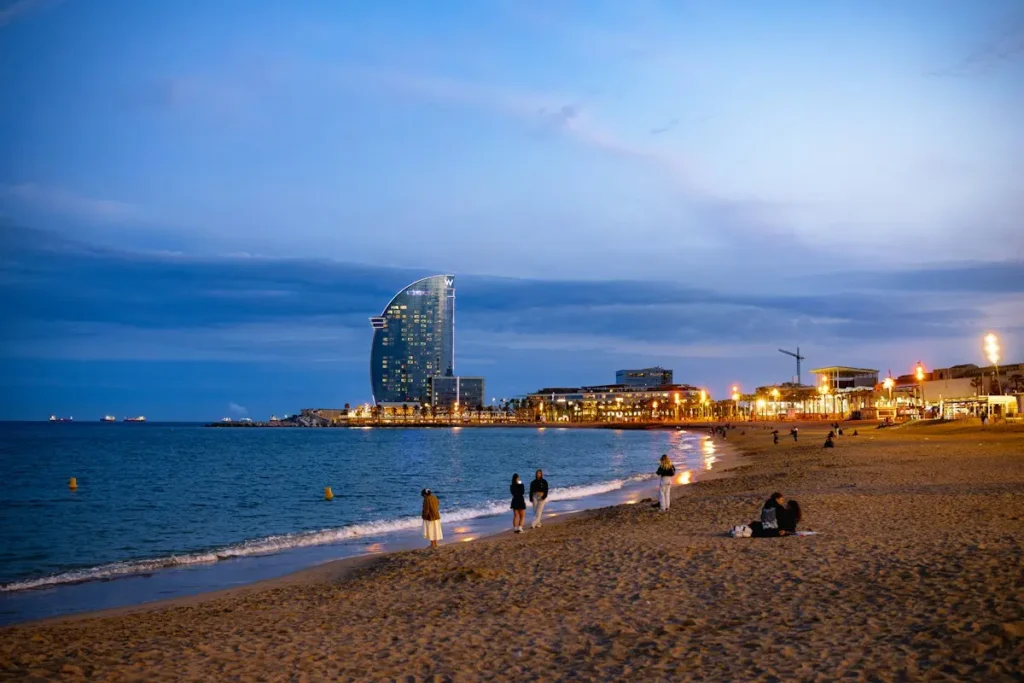 Families on Barceloneta beach at dusk, a favourite stop in Barcelona with kids